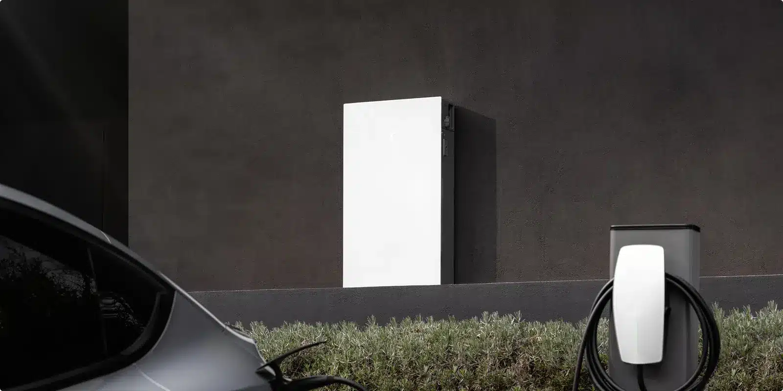 Batterie Tesla Powerwall et borne Wall Connector installées sur un mur extérieur